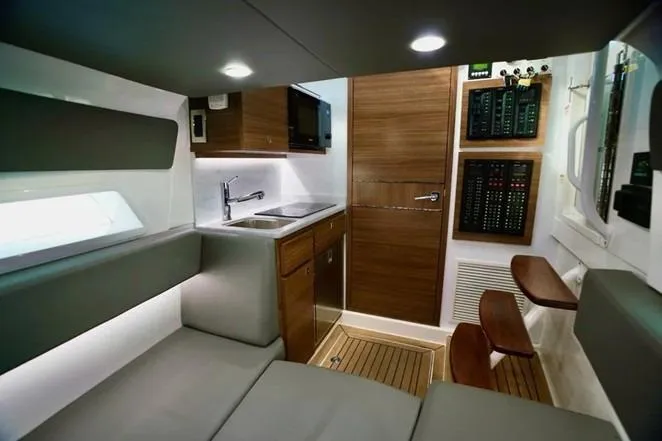 Slide: The Image of 2021 Valhalla Boatworks V-46 interior with kitchenette, seating, and control panels. - 16