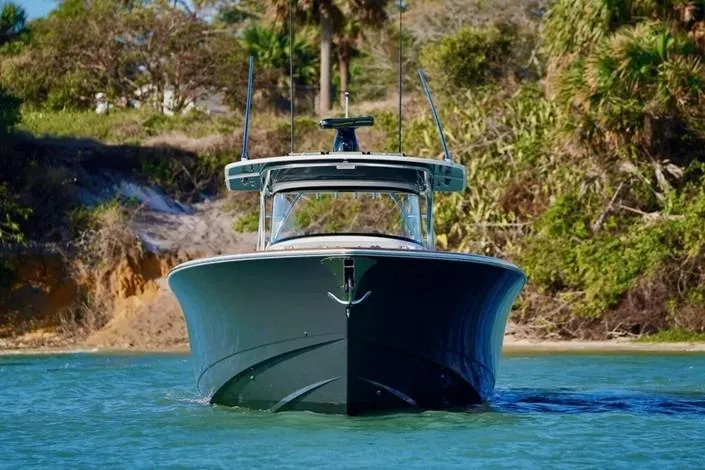 Slide: The Image of 2021 Valhalla Boatworks V-46 cruising in clear waters near a lush shoreline. - 5