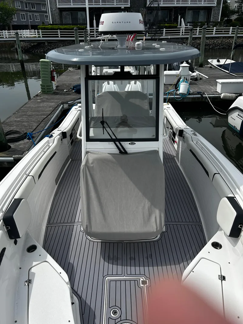 Slide: The Image of 2024 Tidewater 280 CC Adventure boat docked, showcasing sleek design and spacious deck. - 11