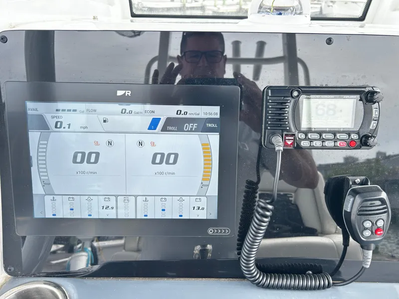 Slide: The Image of 2024 Tidewater 280 CC Adventure dashboard with digital display and marine radio. - 19