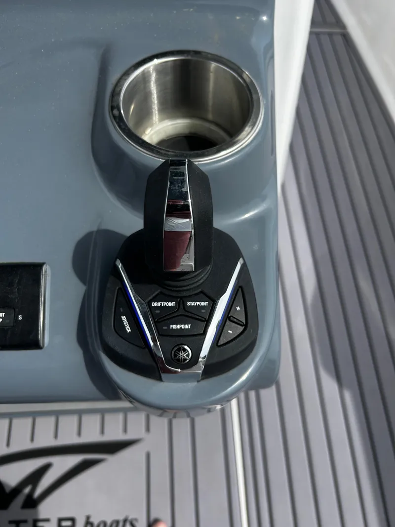Slide: The Image of 2024 Tidewater 280 CC Adventure boat throttle control and cup holder. - 20