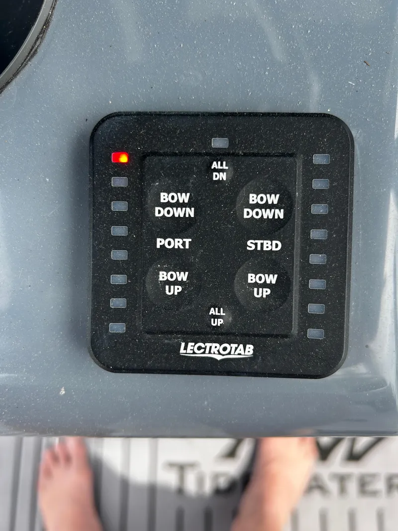 Slide: The Image of Control panel on 2024 Tidewater 280 CC Adventure boat with trim tab buttons. - 21