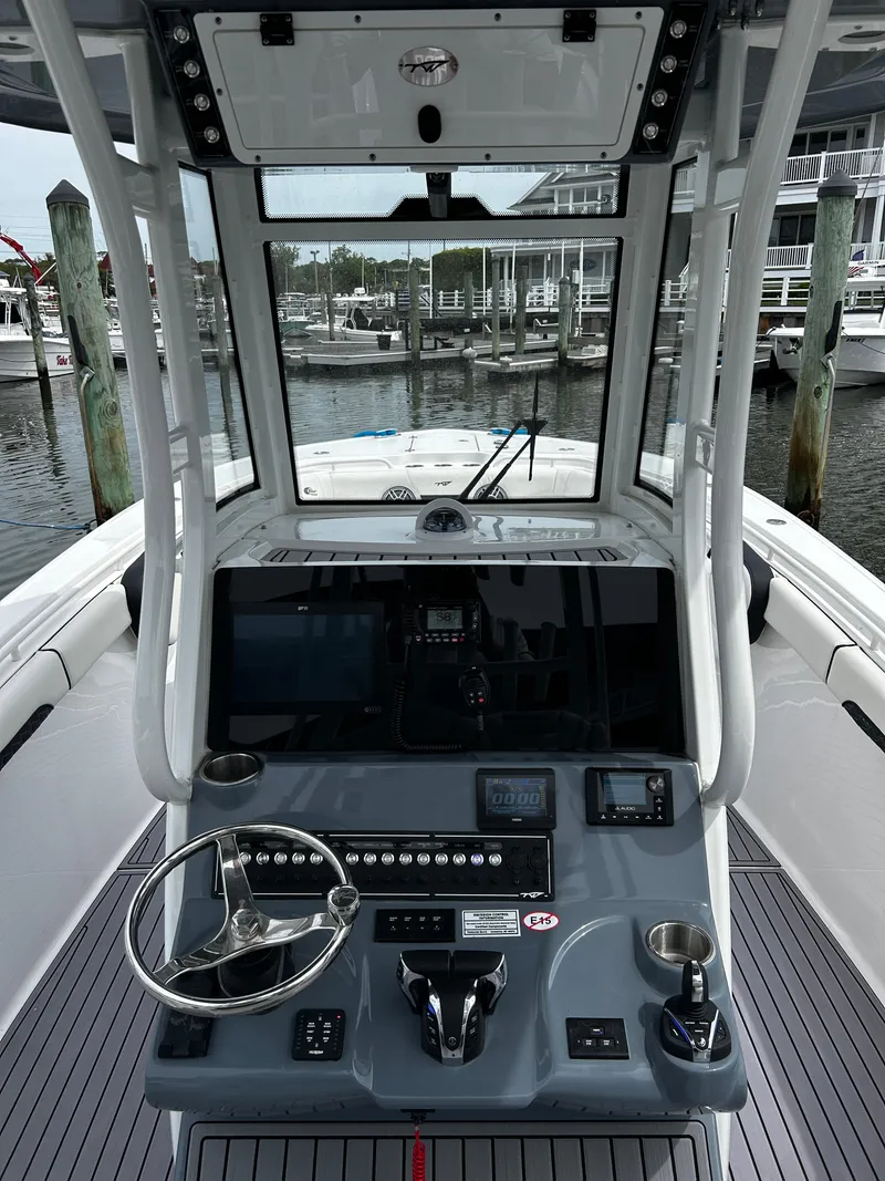 Slide: The Image of 2024 Tidewater 280 CC Adventure boat cockpit with advanced navigation controls and marina backdrop. - 24