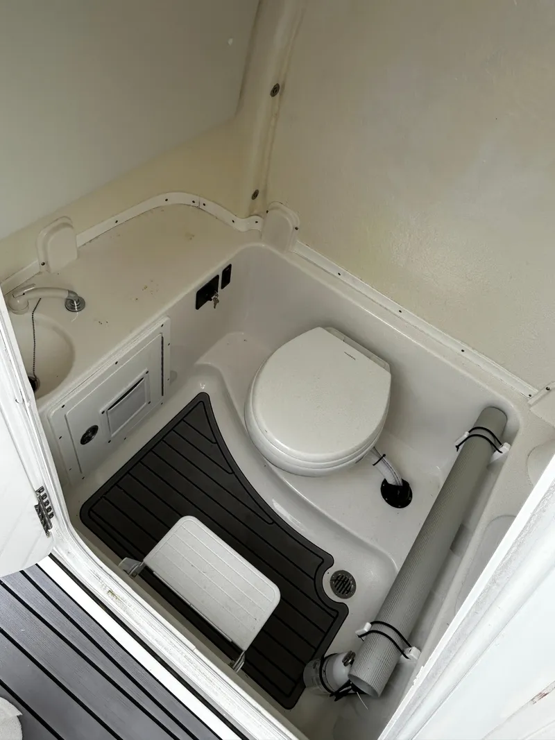 Slide: The Image of 2024 Tidewater 280 CC Adventure boat bathroom with toilet and sink. - 33