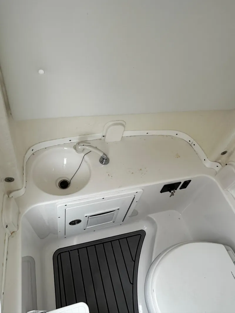 Slide: The Image of 2024 Tidewater 280 CC Adventure boat interior with sink and toilet. - 34