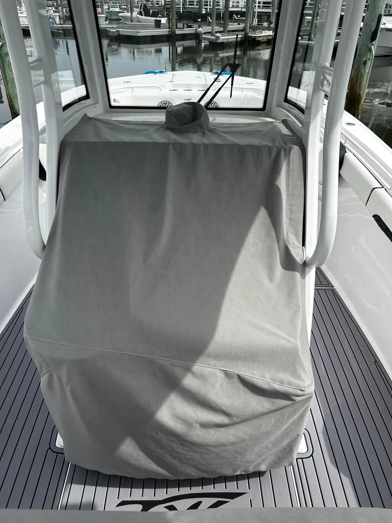 Slide: The Image of 2024 Tidewater 280 CC Adventure boat helm covered, docked at marina. - 9