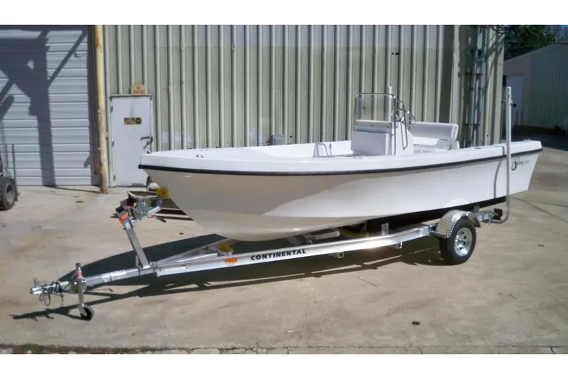 The Image of 2026 C-Hawk 200 Center Console boat on trailer, parked outdoors near blue building. - 0