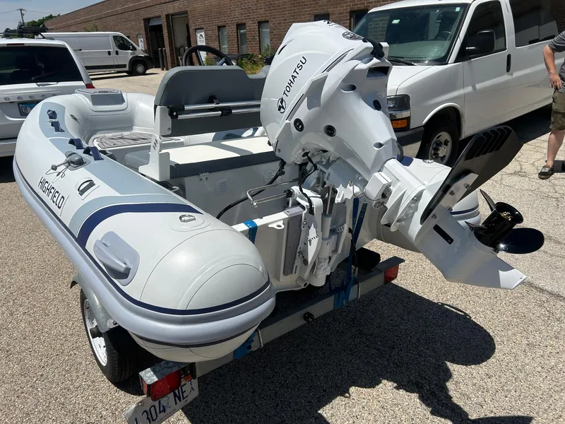 Slide: The Image of 2025 Highfield Classic 310 FCT inflatable boat with Tohatsu outboard motor on a trailer. - 2