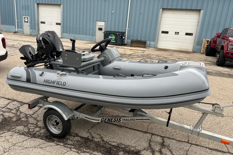 Slide: The Image of 2025 Highfield Classic 310 FCT inflatable boat on Genesis trailer, parked outdoors. - 6