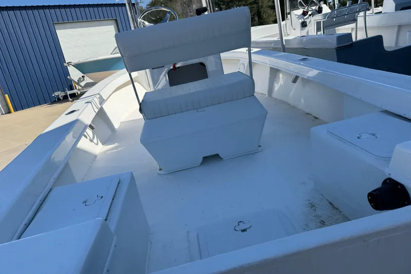 Slide: The Image of 2026 C-Hawk 18 Center Console boat with white interior, docked near blue building. - 14