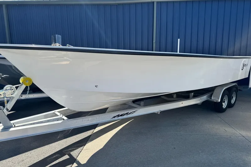 Slide: The Image of 2026 C-Hawk 25 Center Console boat on trailer, parked by blue building. - 10