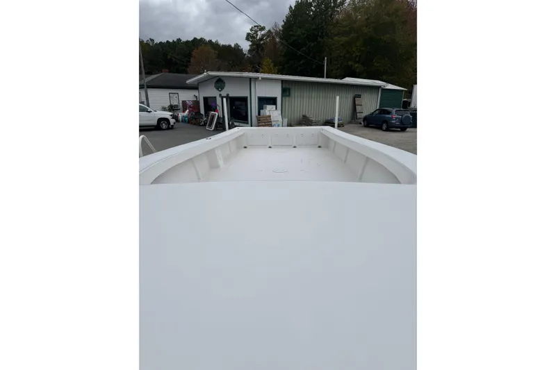 Slide: The Image of 2026 C-Hawk 26 Center Console boat, white deck, parked near buildings and vehicles. - 7