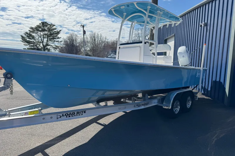 Slide: The Image of 2026 C-Hawk 23 Center Console boat on trailer, blue hull, parked outdoors. - 15
