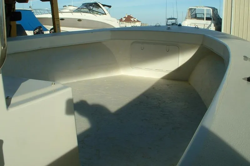 Slide: The Image of 2026 C-Hawk 23 Center Console boat deck with storage compartments, parked outdoors. - 4