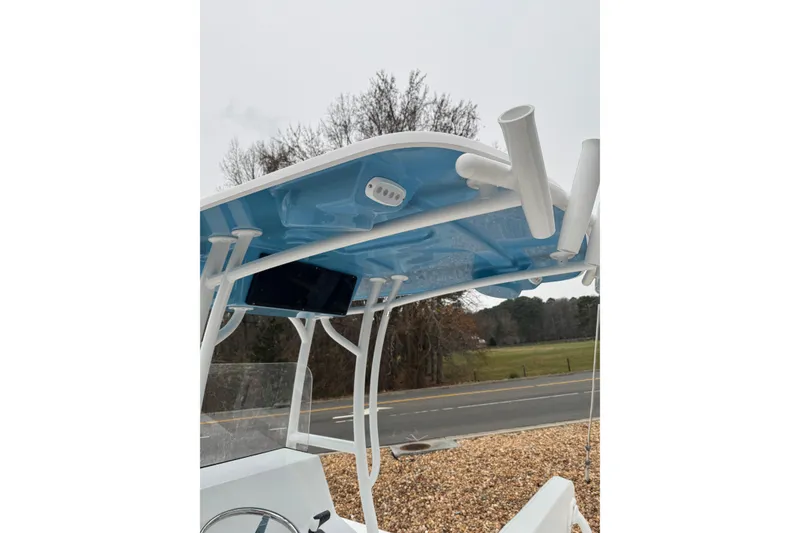 Slide: The Image of 2026 C-Hawk 23 Center Console boat with blue T-top and rod holders. - 5