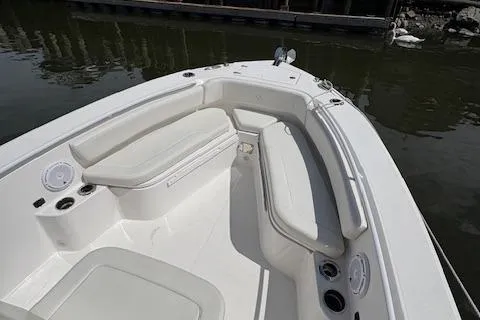 Slide: The Image of 2022 Edgewater 230CC boat interior with white seating and cup holders. - 11