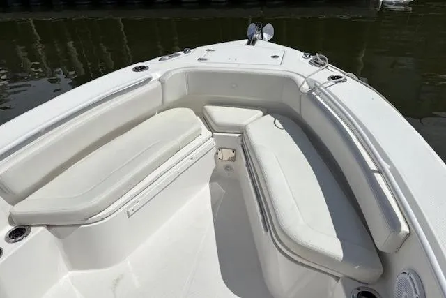 Slide: The Image of 2022 Edgewater 230CC boat with white cushioned seating in the bow area. - 12