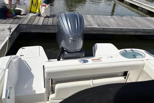 Slide: The Image of 2022 Edgewater 230CC boat with outboard motor docked at marina. - 14