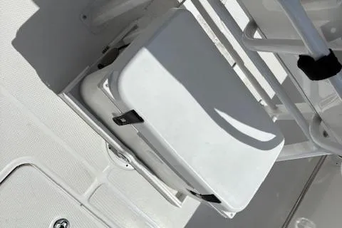 Slide: The Image of 2022 Edgewater 230CC boat interior with white seating and storage compartment. - 17