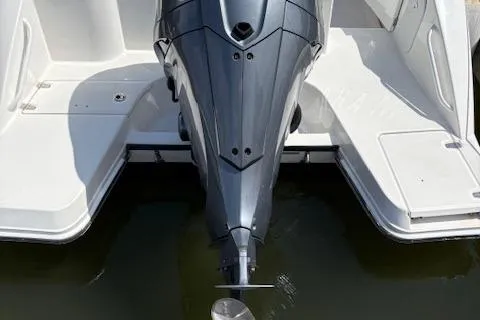 Slide: The Image of 2022 Edgewater 230CC boat with outboard motor, docked on calm water. - 3