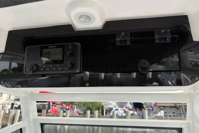 Slide: The Image of 2022 Edgewater 230CC boat dashboard with Garmin marine radio and storage compartment. - 7
