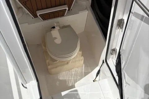 Slide: The Image of 2022 Edgewater 230CC boat interior with compact marine toilet. - 8