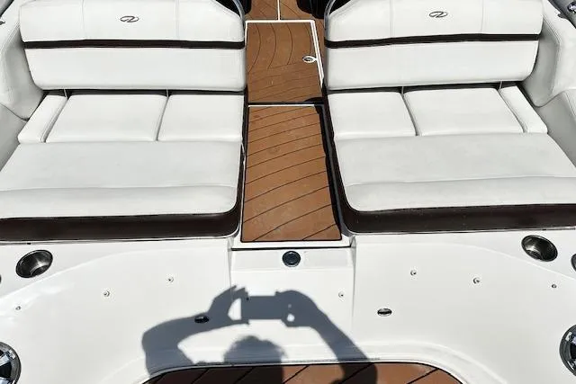 Slide: The Image of 2016 Regal 2800 Bowrider interior with white seating and wooden deck. - 13