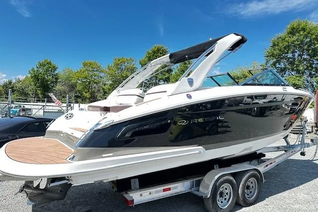 Slide: The Image of 2016 Regal 2800 Bowrider boat on trailer, sleek design, sunny day, outdoor setting. - 2