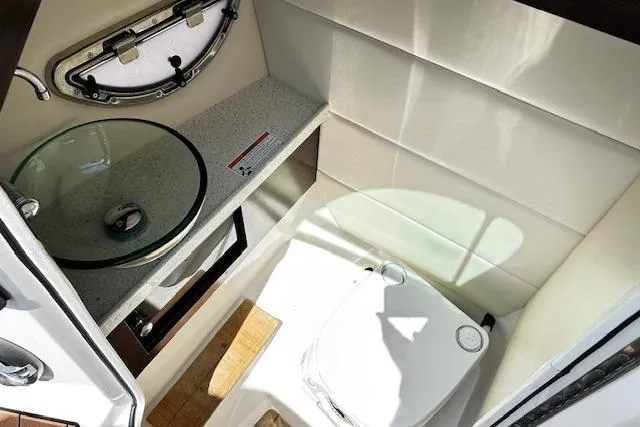 Slide: The Image of 2016 Regal 2800 Bowrider boat bathroom with glass sink and compact toilet. - 21