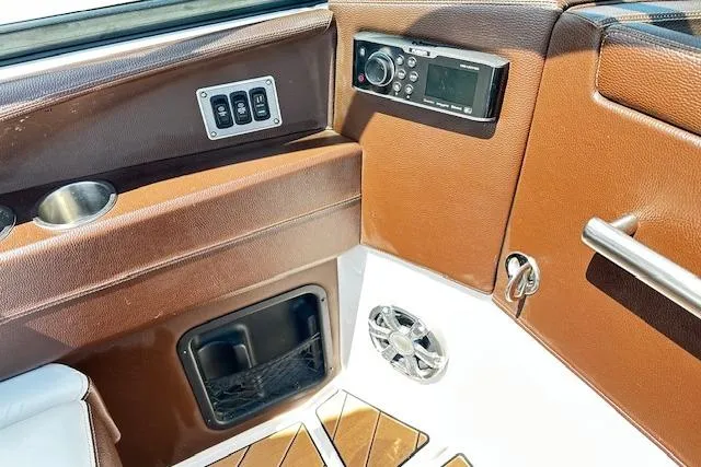 Slide: The Image of 2016 Regal 2800 Bowrider interior with control panel, speaker, and brown leather accents. - 9