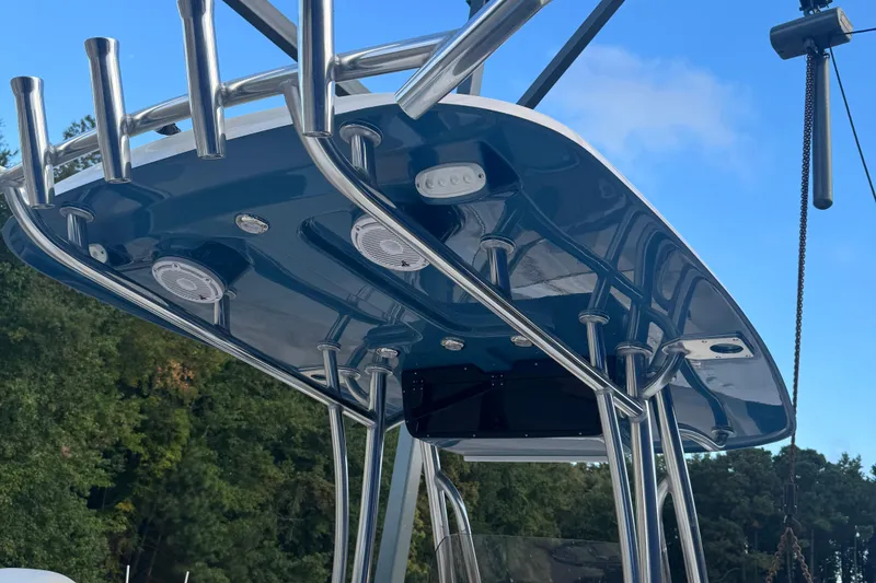 Slide: The Image of T-top of 2026 Bulls Bay 255 boat with rod holders and speakers against blue sky. - 11