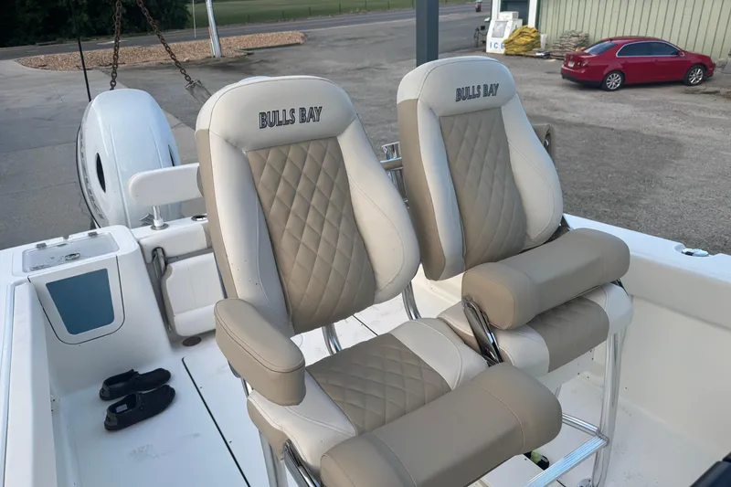 Slide: The Image of 2026 Bulls Bay 255 boat seats with quilted design and armrests, parked outdoors. - 18