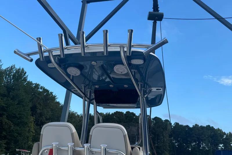Slide: The Image of 2026 Bulls Bay 255 boat with T-top and rod holders against blue sky. - 6