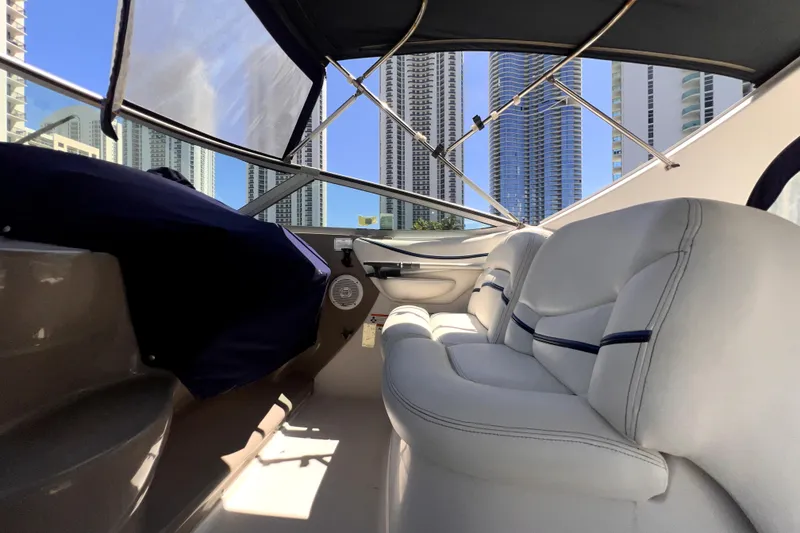 Slide: The Image of 2006 Larson Cabrio 370 boat interior with white seating, city skyline view. - 44
