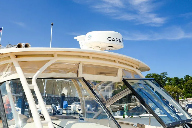 Slide: The Image of 2015 Grady White 335 Freedom boat with Garmin radar, docked under clear blue sky. - 10