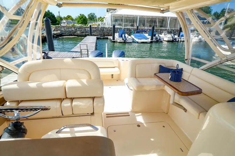 Slide: The Image of 2015 Grady White 335 Freedom boat interior with seating and table, docked at marina. - 13