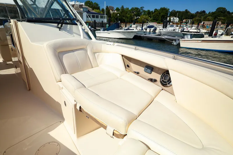 Slide: The Image of 2015 Grady White 335 Freedom boat interior with beige seating, docked at marina. - 14