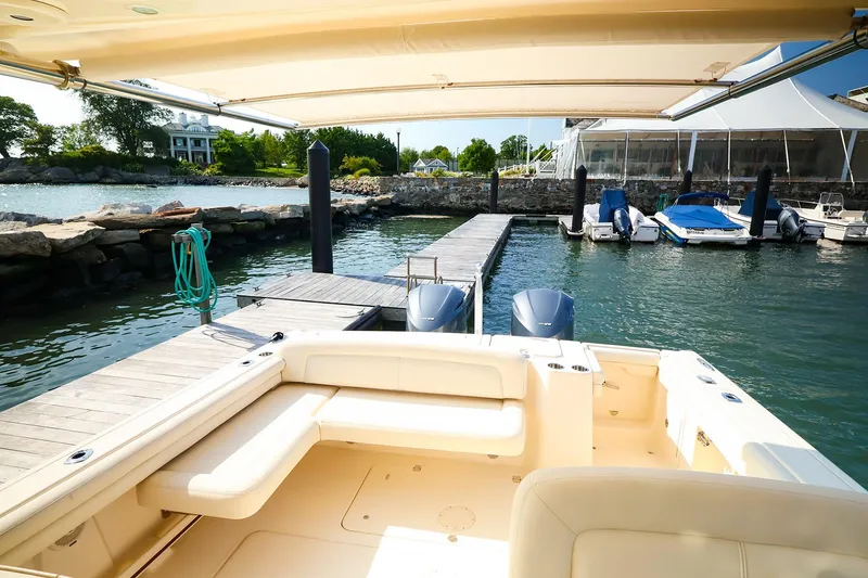 Slide: The Image of 2015 Grady White 335 Freedom boat docked at a marina with scenic waterfront view. - 16