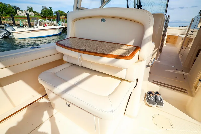 Slide: The Image of 2015 Grady White 335 Freedom boat interior with seating and table, docked by the water. - 17