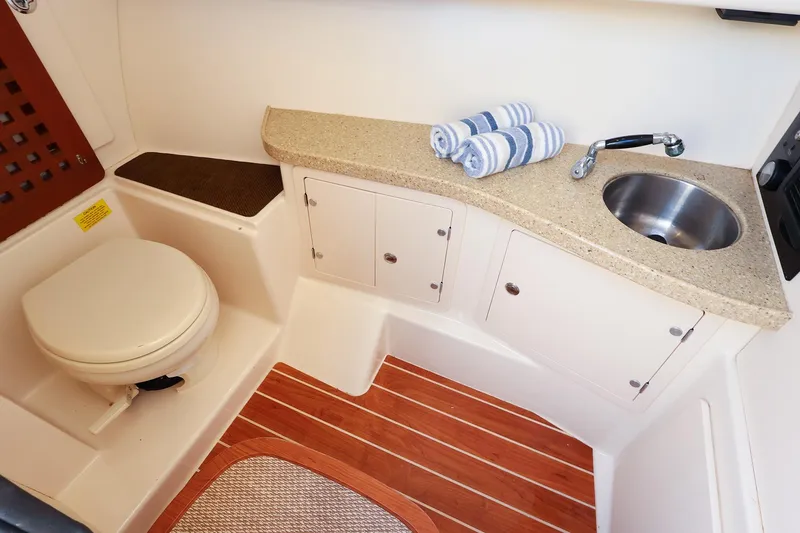 Slide: The Image of 2015 Grady White 335 Freedom boat bathroom with sink, toilet, and wooden flooring. - 34
