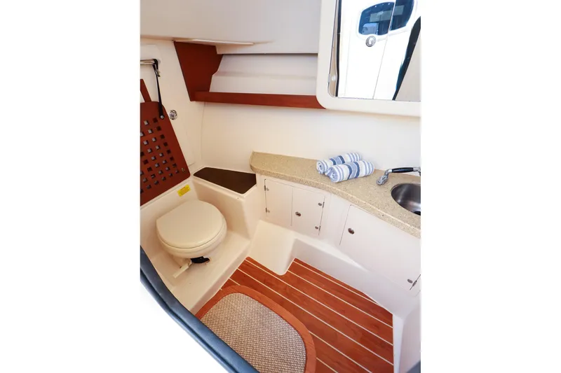 Slide: The Image of 2015 Grady White 335 Freedom boat interior with toilet, sink, and wooden flooring. - 36