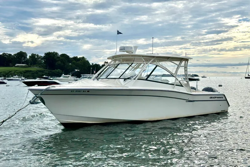 Slide: The Image of 2015 Grady White 335 Freedom boat anchored on a calm lake under a cloudy sky. - 38