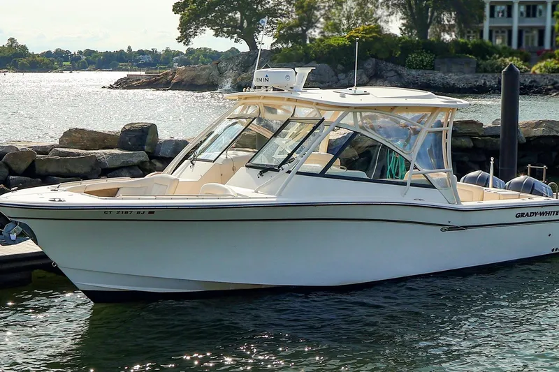 Slide: The Image of 2015 Grady White 335 Freedom boat docked by rocky shoreline. - 4