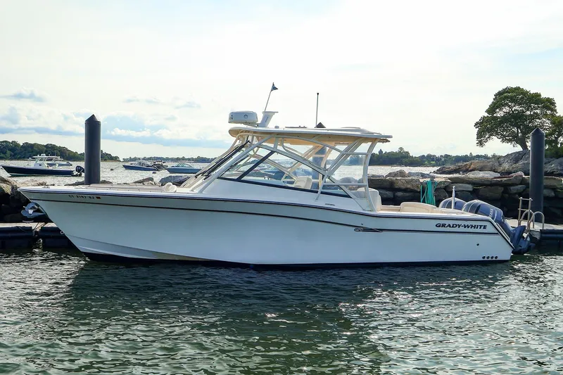 Slide: The Image of 2015 Grady-White 335 Freedom boat docked by rocky shoreline. - 40