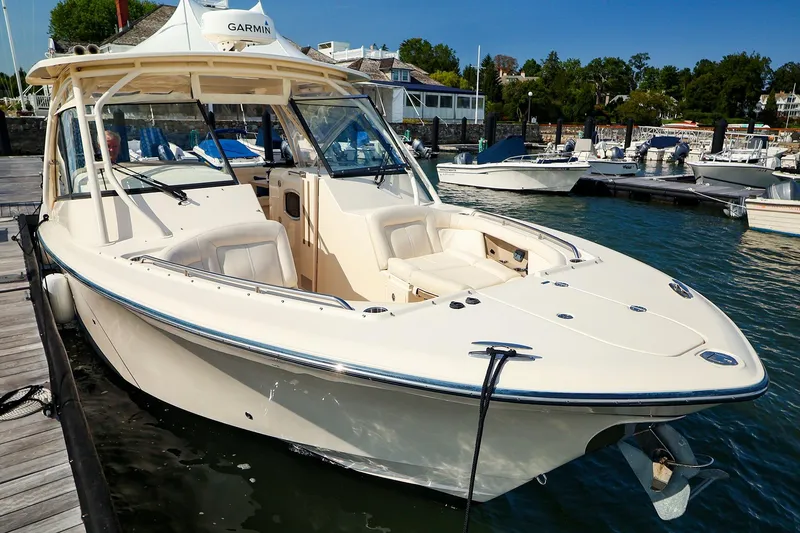 Slide: The Image of 2015 Grady White 335 Freedom boat docked at marina, featuring spacious seating and sleek design. - 5