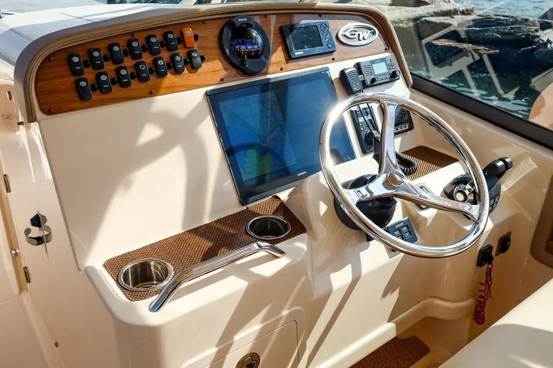 Slide: The Image of Control panel of a 2015 Grady White 335 Freedom boat with steering wheel and navigation screen. - 6