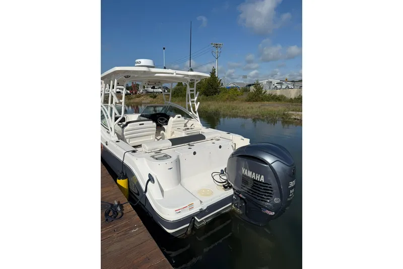 Slide: The Image of 2022 Robalo R247 Dual Console boat with Yamaha outboard engine docked on calm water. - 12