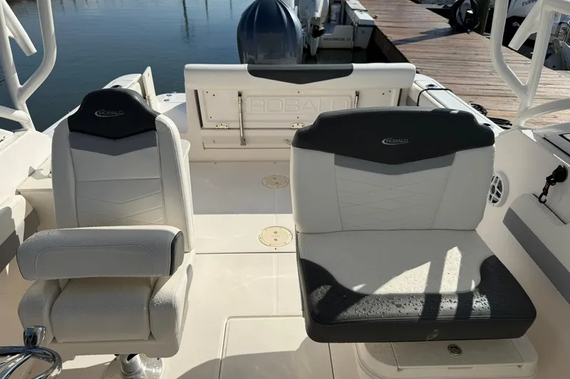 Slide: The Image of 2022 Robalo R247 Dual Console boat interior with cushioned seating and helm. - 15