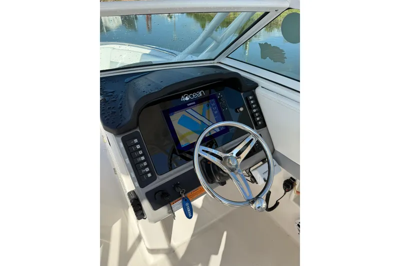 Slide: The Image of 2022 Robalo R247 Dual Console boat dashboard with steering wheel and navigation display. - 16