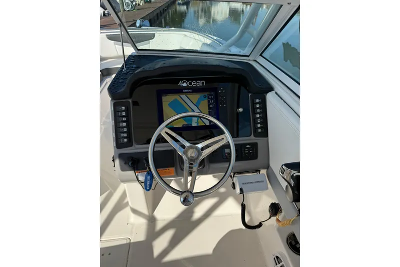 Slide: The Image of 2022 Robalo R247 Dual Console boat dashboard with steering wheel and navigation display. - 17